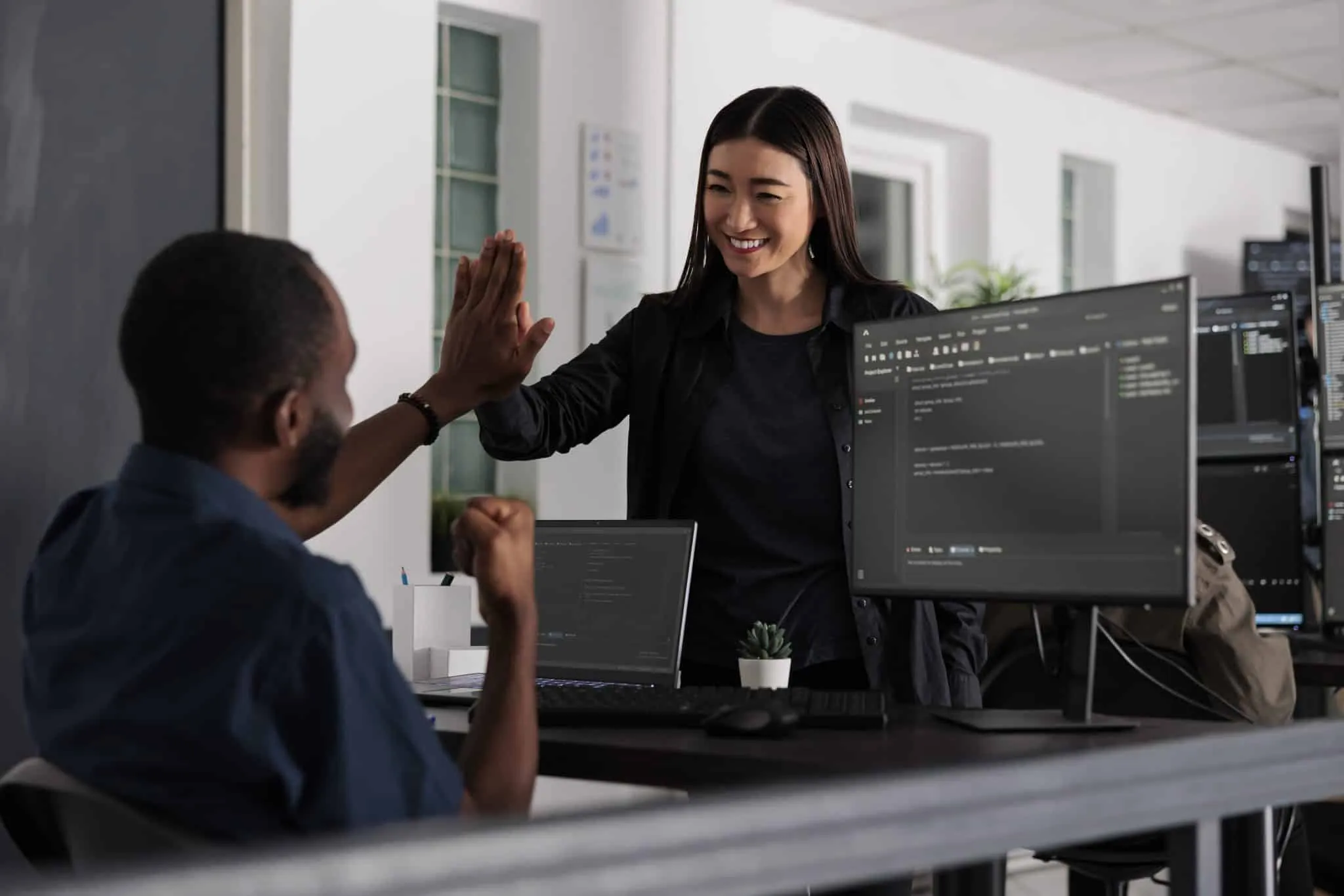 Happy system engineers celebrating successful code script compiling, doing highfive hand gesture after system development. Team of web developers analyzing algorithm and creating app server interface.