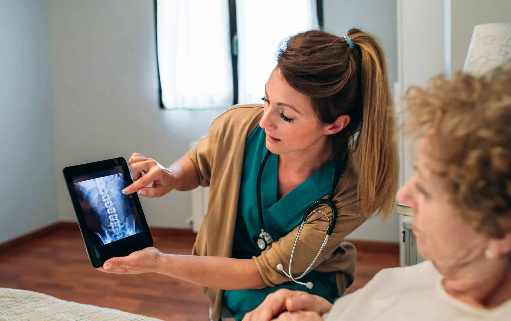 Female doctor showing an x-ray on the tablet