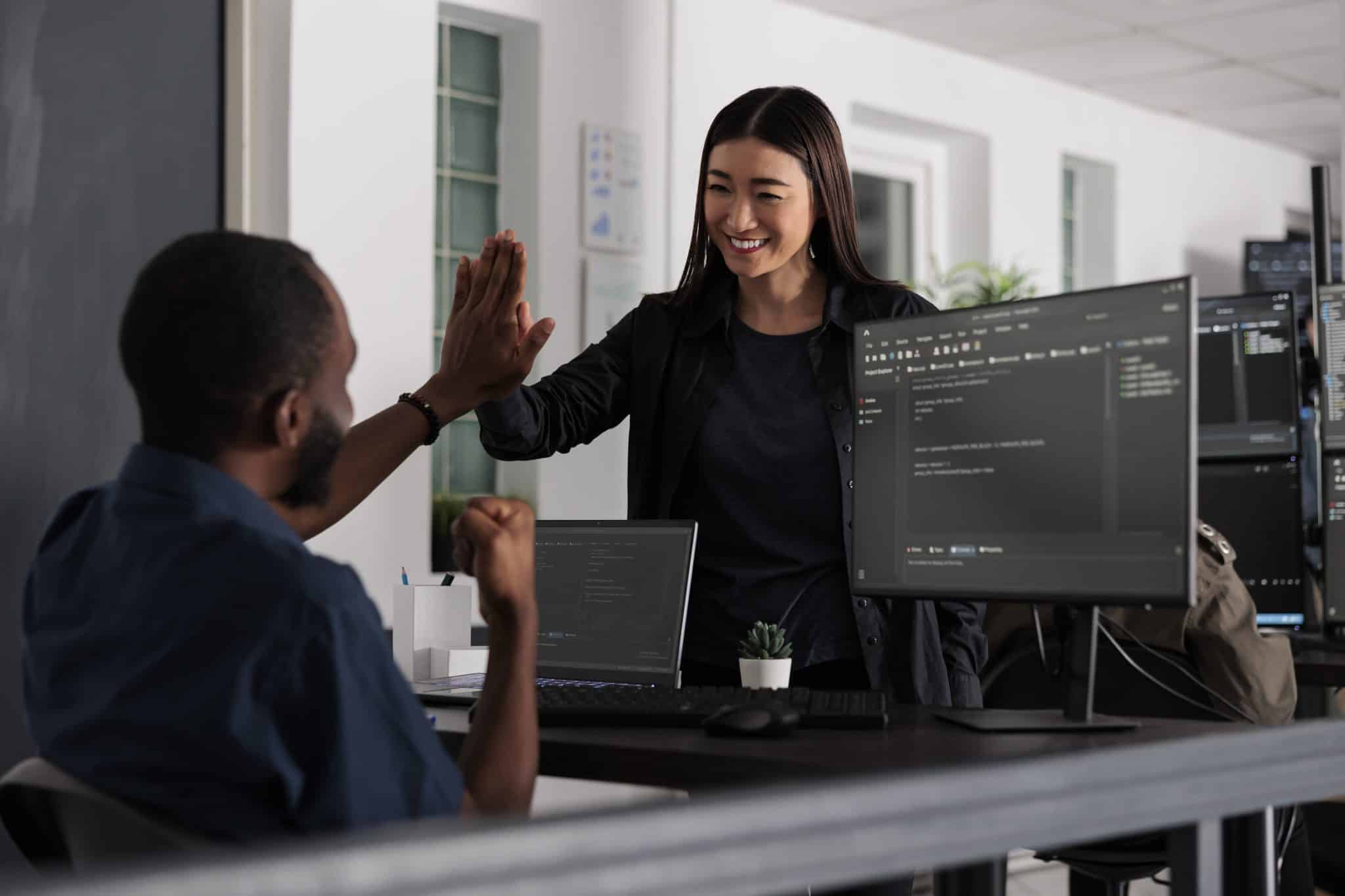 Happy system engineers celebrating successful code script compiling, doing highfive hand gesture after system development. Team of web developers analyzing algorithm and creating app server interface.