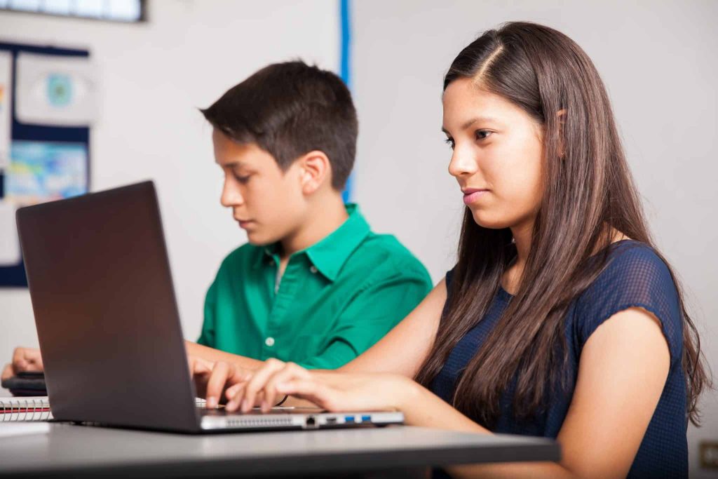 young girl using computer at school