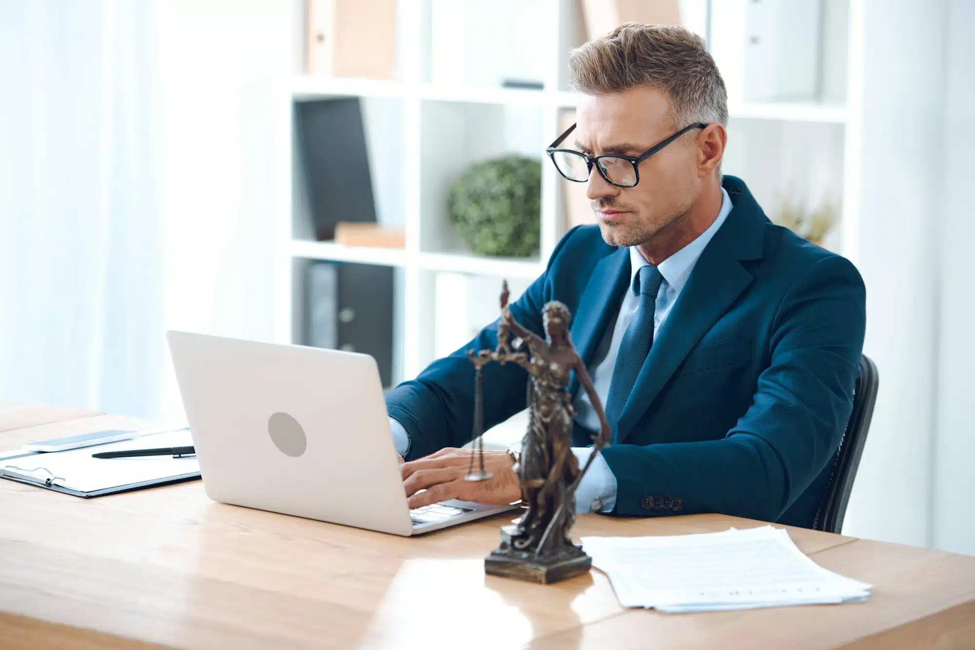 handsome-lawyer-in-eyeglasses-using-laptop-at-workplace handsome-lawyer-in-eyeglasses-using-laptop-at-workplace