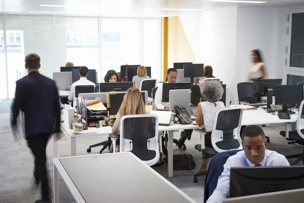 man-walking-through-a-busy-open-plan-office-2023-11-27-05-06-53-utc-scaled