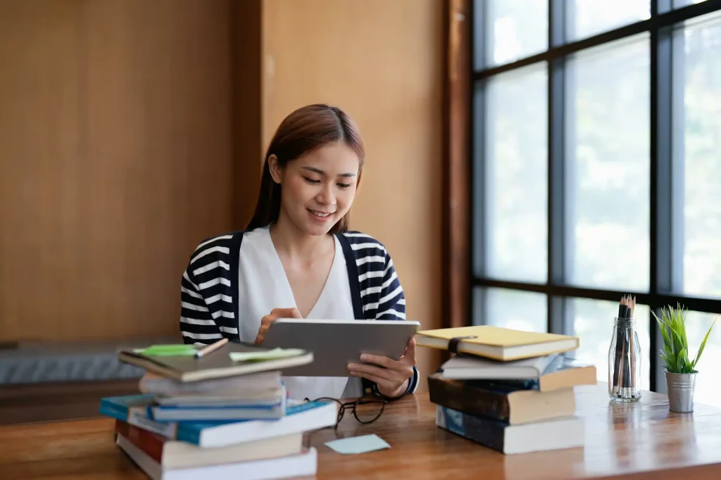 young-asian-woman-student-working-on-digital-tablet-in-library-